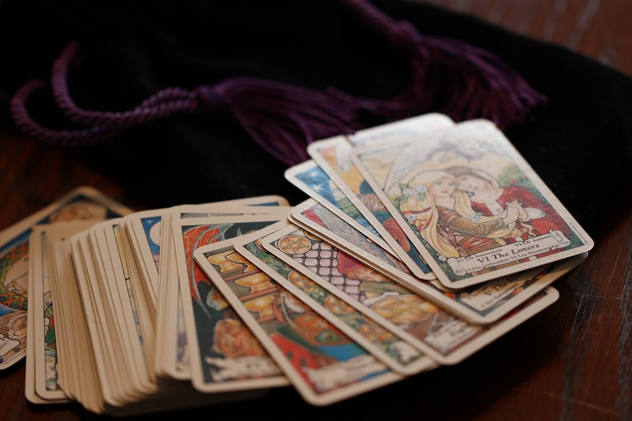 Cartes de tarot disposées en arc sur une table lumineuse
